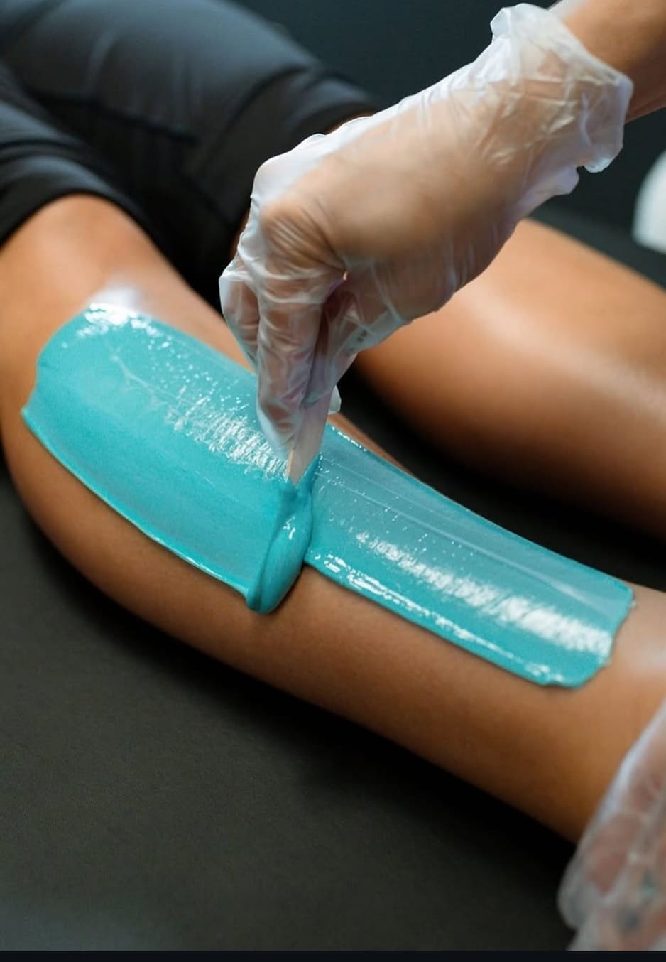 Woman receiving an at-home leg waxing service